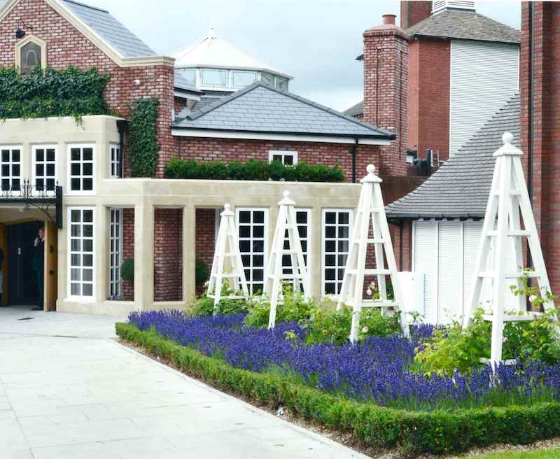 Wooden garden obelisks with roses and lavender plants at the entrance to The Belfry Hotel