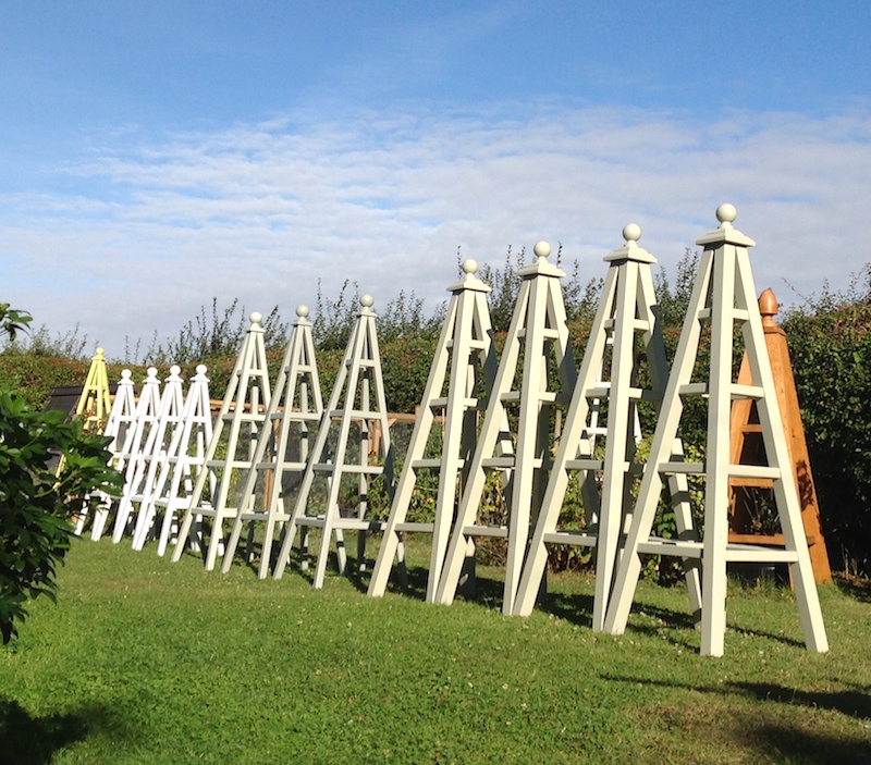 Group of painted wooden garden obelisks in garden at home, includes 4 Large Painted Obelisks